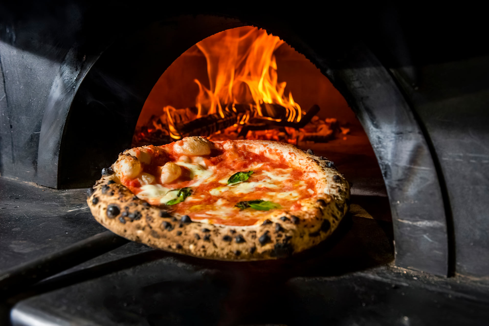 Pizza cotta nel forno a legna